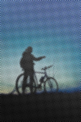 Man with bicycle at sunset - color halftone pattern background