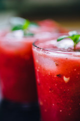 From above view of two glass of red smoothie with ice and fresh leafs mint