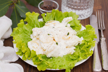 potato salad on white plate on wooden background
