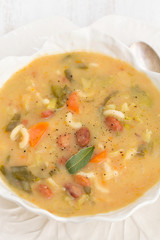 vegetable soup with beans, spinach and pasta in white bowl