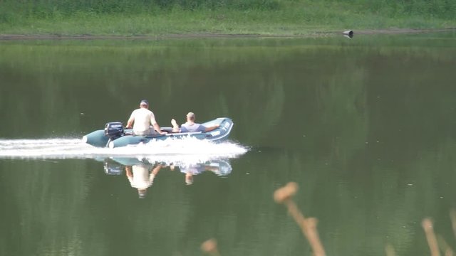 Fishermen on a boat on the river. Two men ride a motor boat on the river.