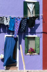 Blue laundry hanging to dry outside a purple house