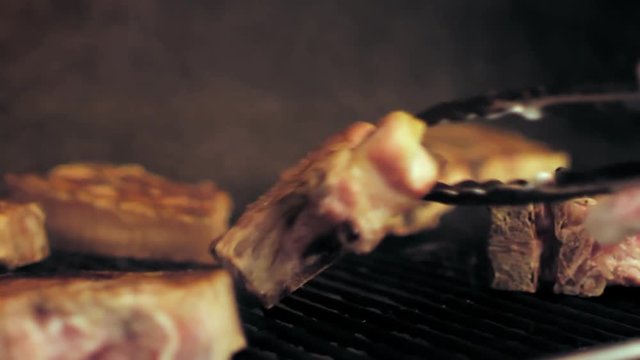 Meat steaks are being fried on a grill rack