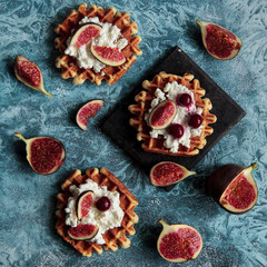 Overhead still life of belgian biscuit waffles with cottage cheese, fresh figs and cherry. Healthy vegetarian breakfast.