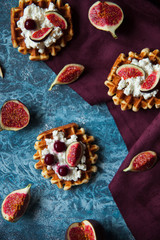 Overhead still life of belgian biscuit waffles with cottage cheese, fresh figs and cherry. Healthy vegetarian breakfast.
