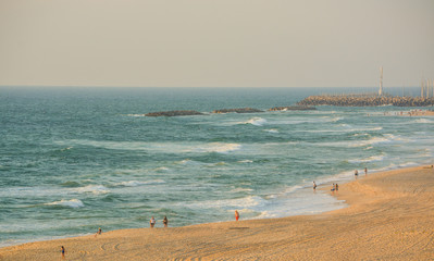 Fototapeta na wymiar People walking on the beach of the Mediterranean Sea in Israel