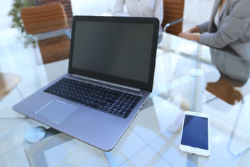 laptop and a smartphone on the desktop of a businessman