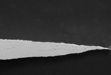 Ripped paper on black background, space for advertising copy.