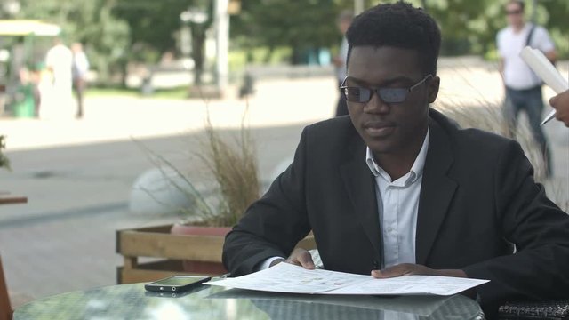 Afro american business man ordering in outside cafe