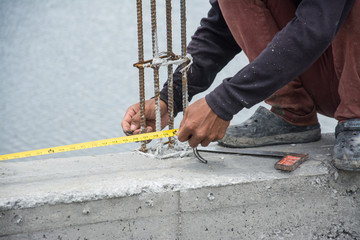worker with measuring tape an steel tie