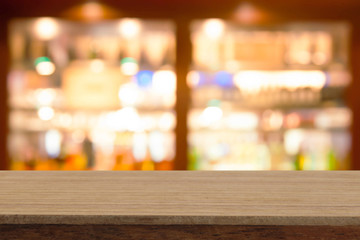 Perspective wooden table on top over blur  wine bar in cafe background, can be used mock up for...
