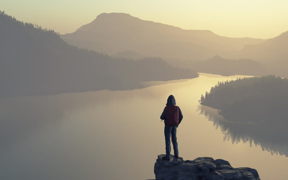 A Man Looks Over The Top Of The Mountain Lake And Forest.