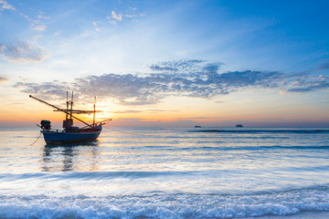 Fototapeta na wymiar Sunrise over on the beach with boats