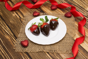 Fresh strawberries dipped in dark chocolate and heart on wooden background. Valentine's Day