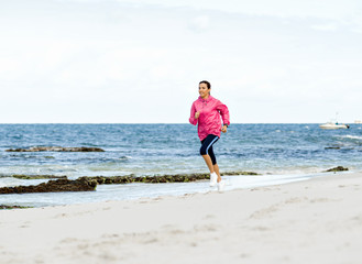 Fototapeta na wymiar Young Woman Jogging On The Beach