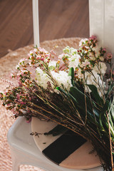 Beautiful cut flowers sitting on a white chair close up