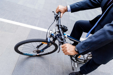 Successful businessman riding bicycle