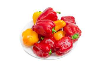 Washed red and yellow bell peppers on a white dish