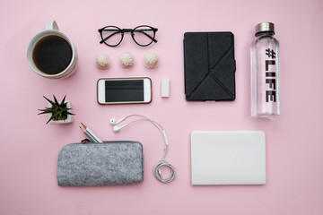 Creative flat lay of workspace desk, with  notebook, phone, sheet, pencils, candy, coffee, water, headphones, plant, pencils on pink background. flat lay top view concept.