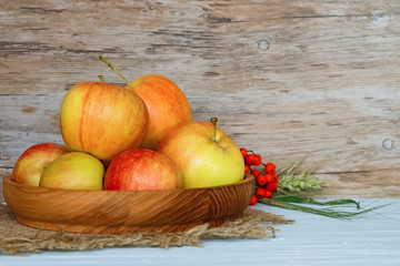 Yellow apples in the plate of wood on a wooden vintage background with empty place for text