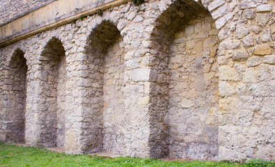Obraz premium Arches in castle walls and green grass