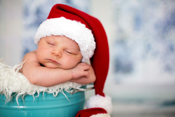 Portrait of a newborn baby boy,l wearing christmas hat, sleeping