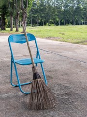 stick broom with blue chair on road