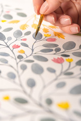 Side view of artist drawing flowers design at workplace