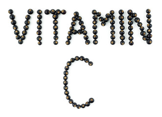 Vitamin C. Words are made up of natural fresh organic berries of black currant on a white background. Top view