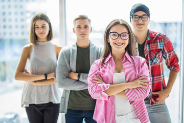 Serious students woman in front with arms folded standing in front of panoramic window