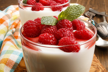 fresh yogurt with raspberries and sauce in a glass