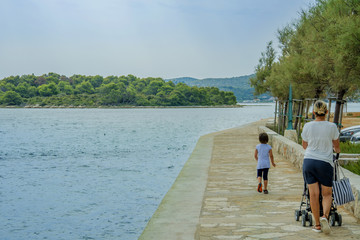 tourists walking down the stone beach near the sea