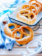 Traditional German pretzels with sea salt on a wooden background in a marine style. Oktoberfest. Homemade baking.