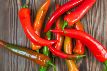 Bunch of chili peppers on rustic wooden table.