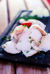 Ukrainian salted fat cut into pieces on a wooden tray.