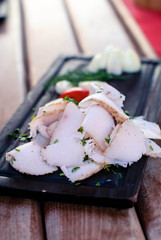 Ukrainian salted fat cut into pieces on a wooden tray.