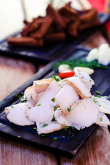 Ukrainian salted lard with croutons and garlic on a wooden tray.