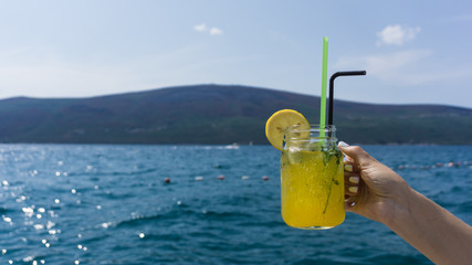 a glass of cocktail on the background of the sea in good weather