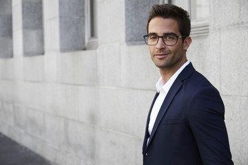Suited businessman smiling in glasses, portrait