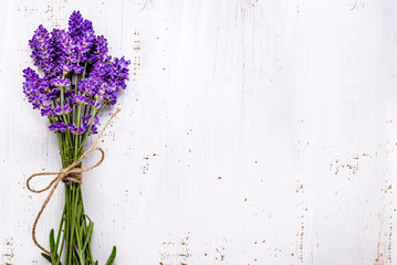 Fresh flowers of lavender bouquet, top view on white wooden background