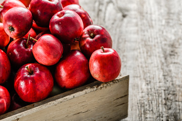 Red apples on table on wooden rustic background, fresh apple fruits on farmer market