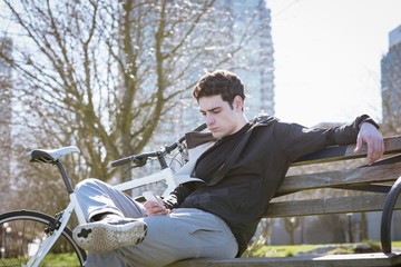 Man using mobile phone while sitting on bench
