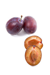 Group of whole and half of ripe plums isolated on a white background..