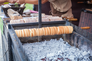 trdelník is baked on the charcoal grill and offered for sale at markets