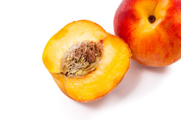 Ripe peach fruit and a half isolated on white background.