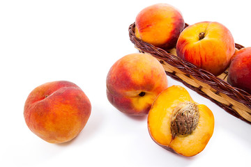 Fototapeta na wymiar Whole and half of ripe peach fruit and several in basket isolated on white background.