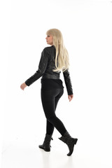 Fototapeta premium full length portrait of blonde girl wearing black leather outfit, standing pose on white background.