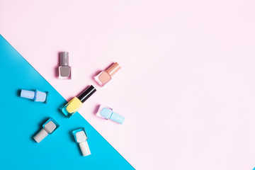 Creative flat lay of fashion bright nail polishes on a colorful background. Minimal style. Copy space. Beauty blogger concept. Top view.