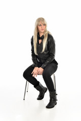 Fototapeta premium full length portrait of a blonde girl wearing black leather pose, crouching pose on white background.