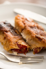 Grilled and fried in eggs paprika with knife and fork on the plate